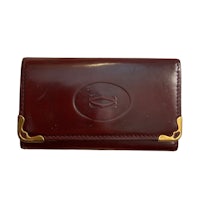 a burgundy leather wallet with gold trim