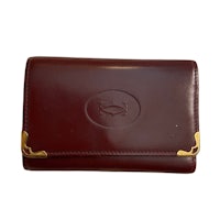 a burgundy leather wallet with gold trim