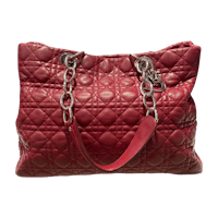 a red quilted tote bag with chain handles