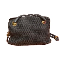 a black woven handbag with gold hardware